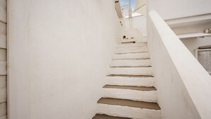 Een witte trap die naar een gebouw met een witte gevel leidt.