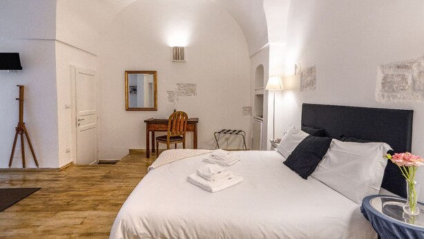 Une chambre à coucher avec un lit, un bureau, une chaise et une lampe.