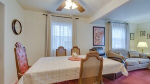A dining area with a table set for four, surrounded by wooden chairs. A ceiling fan is visible above the table. - Convenient, Pet-friendly Rochester Vacation Rental (Rochester)