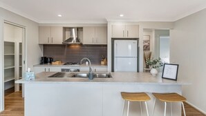 A modern kitchen with a central island, stainless steel appliances, and a minimalist design.