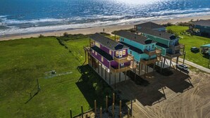 A beachfront property with elevated structures, a sandy beach, and a view of the ocean. - Beachfront | Spacious, Pet-Friendly & Relaxing (Gilchrist)