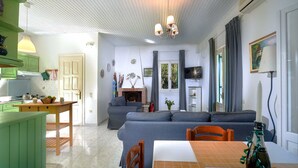 Una sala de estar acogedora con chimenea, un comedor con mesa y sillas, y una cocina con estufa y armarios.