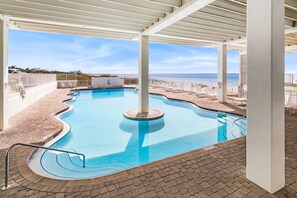 En swimmingpool med udsigt til stranden og havet.