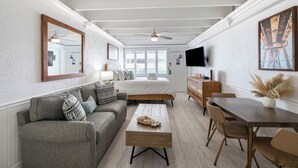 A modern living room with a sofa, coffee table, and dining table.