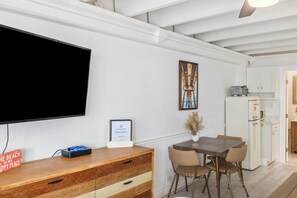 Et moderne køkken med hvide skabe, indbygget mikroovn og køleskab.
