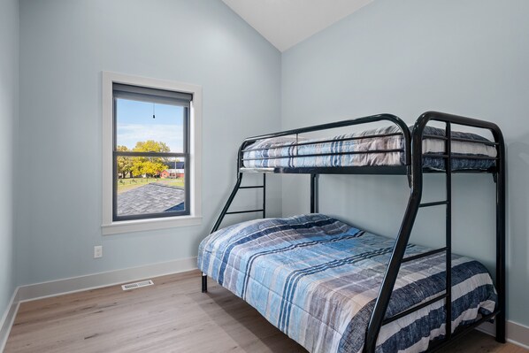 A bunk bed room with a window overlooking a parking area. - Newer Cottage on all sports lake, pontoon boat available (Trufant)