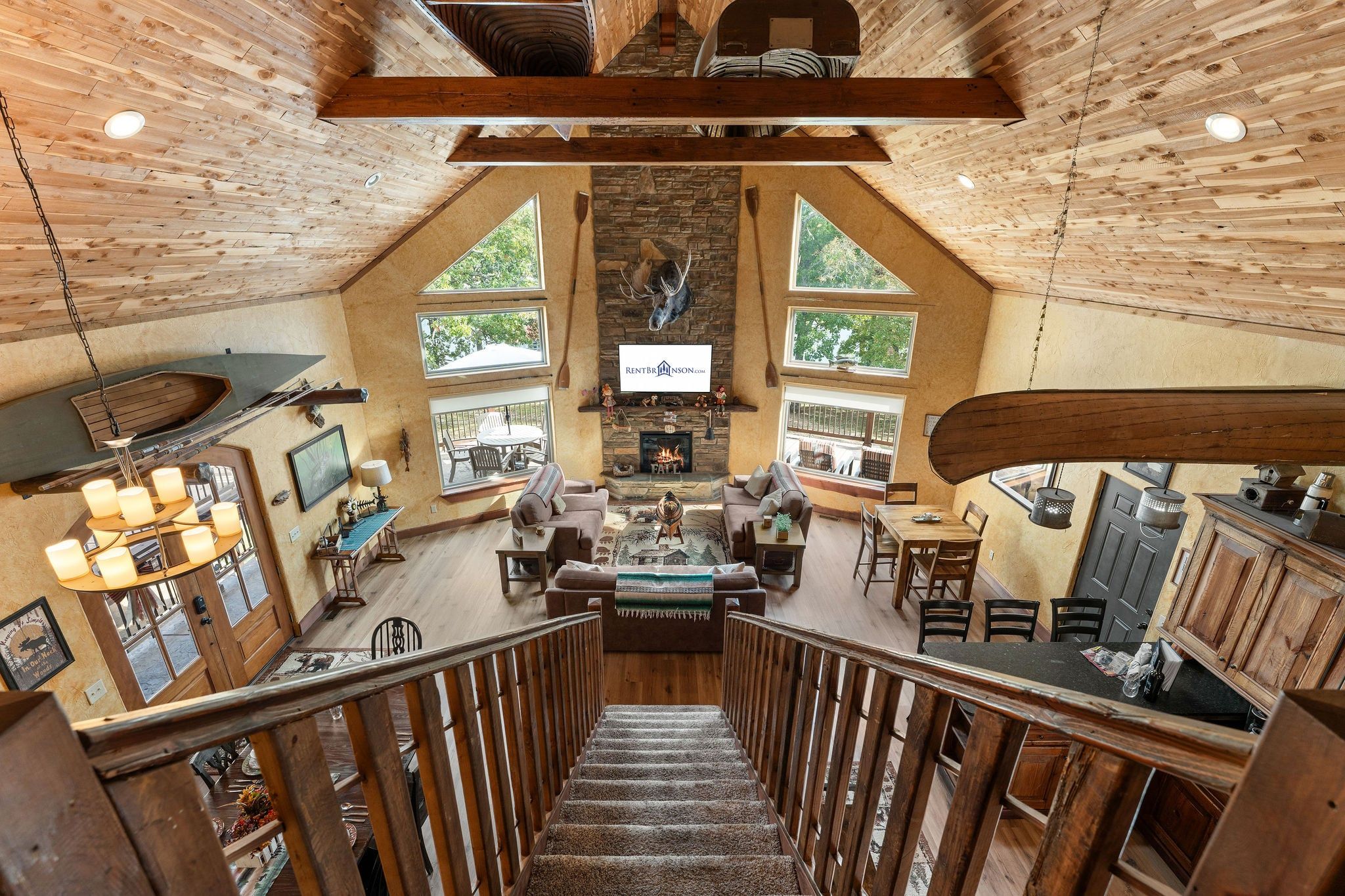 A spacious interior with a fireplace, seating area, and a staircase leading to an upper level.