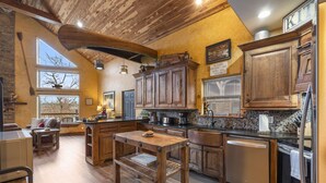 Une cuisine spacieuse dotée de meubles en bois, d’un îlot central et d’un coin repas avec une table et des chaises.
