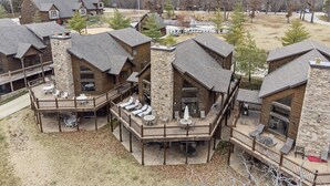 Un chalet à étages doté d’une façade en pierre, de nombreux balcons et d’espaces de détente en plein air.