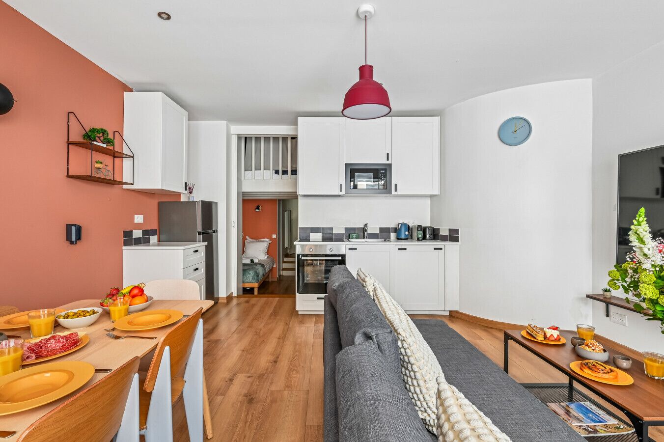 Un espacio habitable compacto con comedor, kitchenette y sofá.