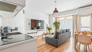 A modern apartment with a kitchen, dining area, and living room.