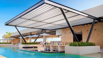 A poolside area with a covered seating area, lounge chairs, and a bar with a variety of bottles.