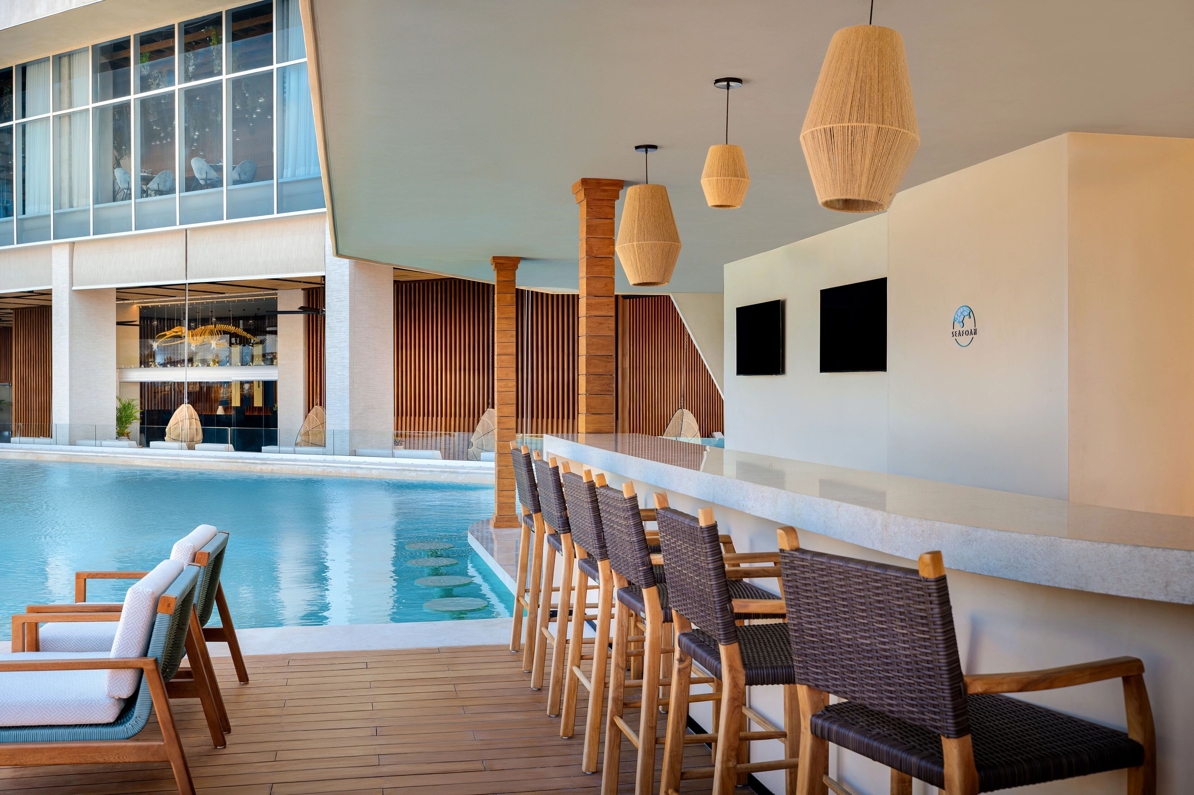 A poolside area with wooden chairs and a bar.