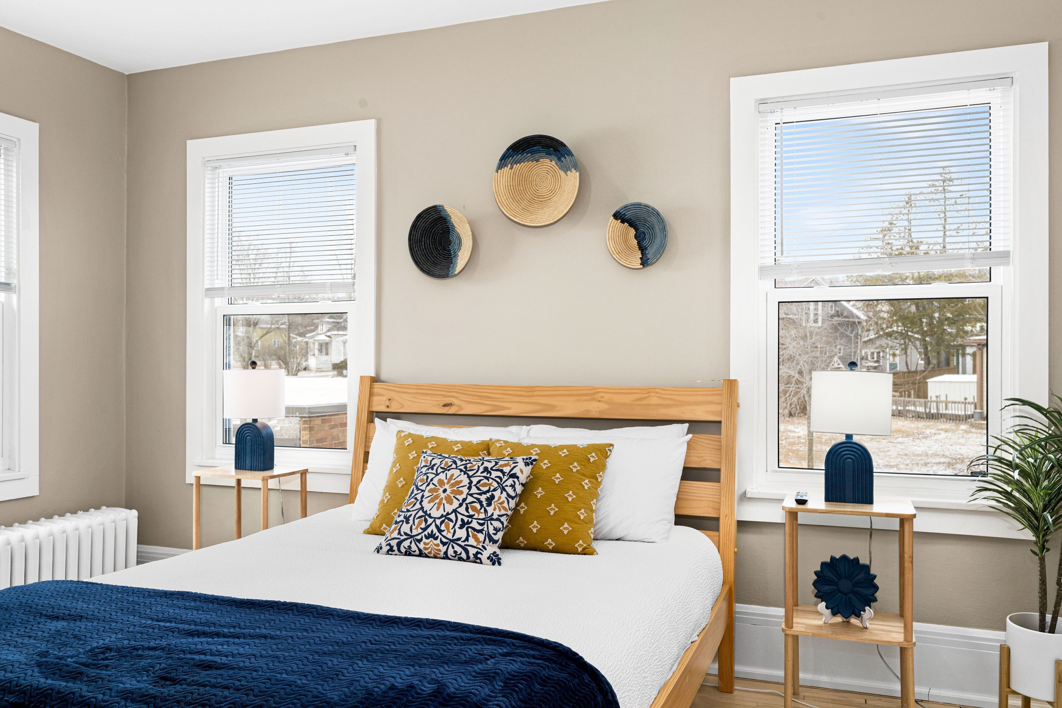 A bedroom with a bed, bedside tables, a window, and wall decor.