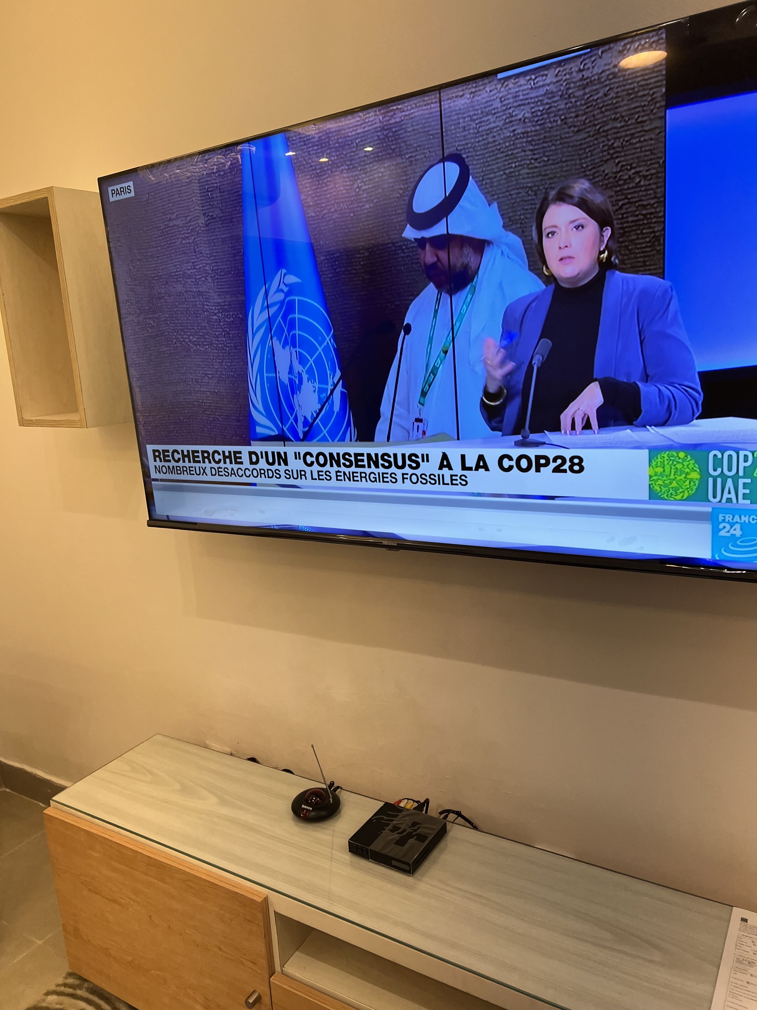 Un televisor mostrando un noticiero con un subtítulo sobre la COP28.
