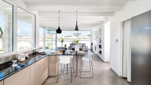 Una cocina moderna con una isla grande, taburetes de bar y vistas a la ciudad.