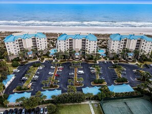 Un hôtel situé en bord de mer, composé de plusieurs bâtiments, doté d’un parking et d’un espace piscine.