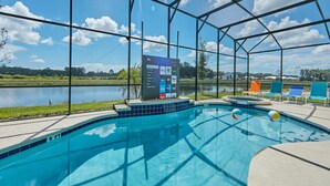Ein Pool mit Seeblick, umgeben von einer überdachten Fläche mit einem Schild, das verschiedene Streaming-Dienste bewirbt.