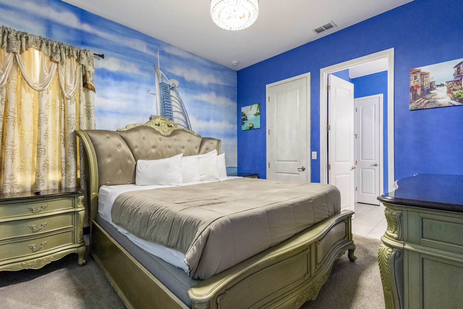 Une chambre à coucher avec un lit, des rideaux, une commode et une porte.