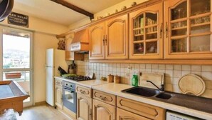 A kitchen with wooden cabinets, a sink, and a stove.