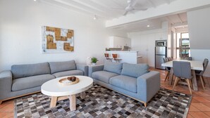 A modern living room with grey sofas, a white coffee table, and a patterned rug.