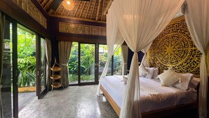 A bedroom with a canopy bed, large windows, and a ceiling fan. - Joyously Raw Villas (Ubud)