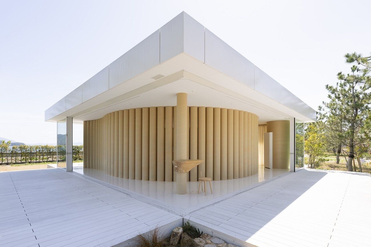 Un bâtiment moderne doté d’une structure centrale circulaire, de grandes fenêtres en verre et d’un toit plat.