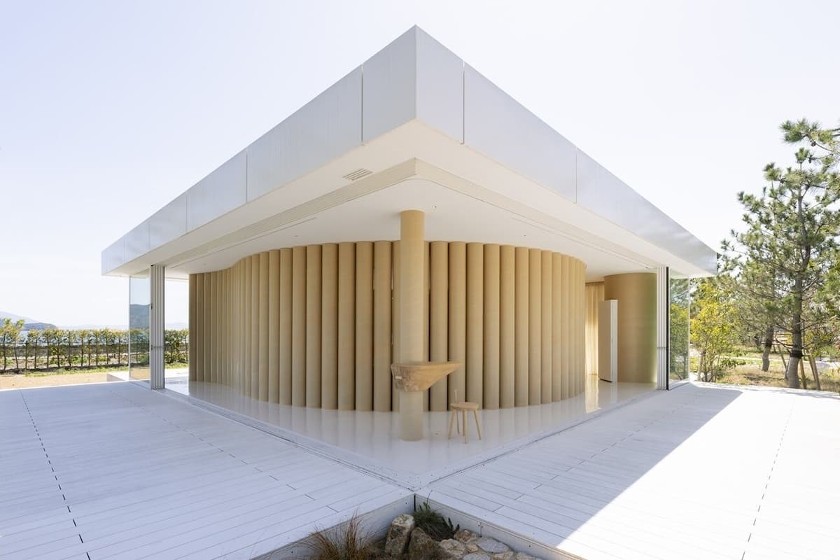A modern building with a circular central structure, large glass windows, and a flat roof.