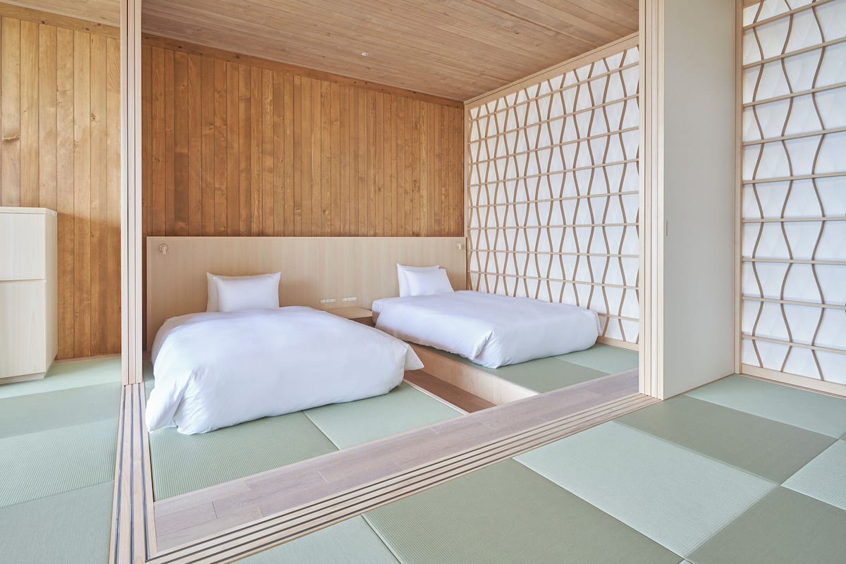 A traditional Japanese-style room with tatami flooring, a low wooden ceiling, and a shoji screen.