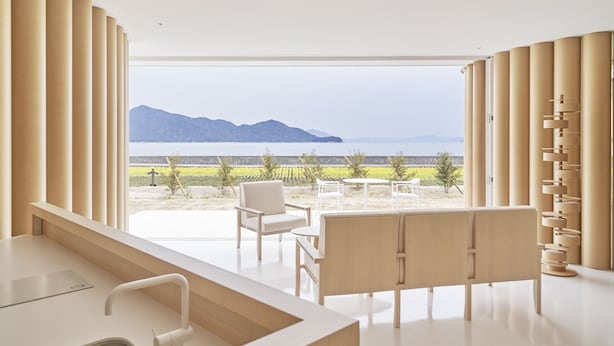 A modern room with a large window, a sink, a bench, and a chair. - Simose Art Garden Villa (Otake)