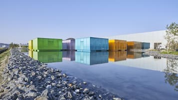 Ein modernes Gebäude mit einer spiegelnden Wasseroberfläche davor.