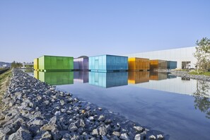 Un edificio moderno con una superficie acuática reflectante en primer plano.