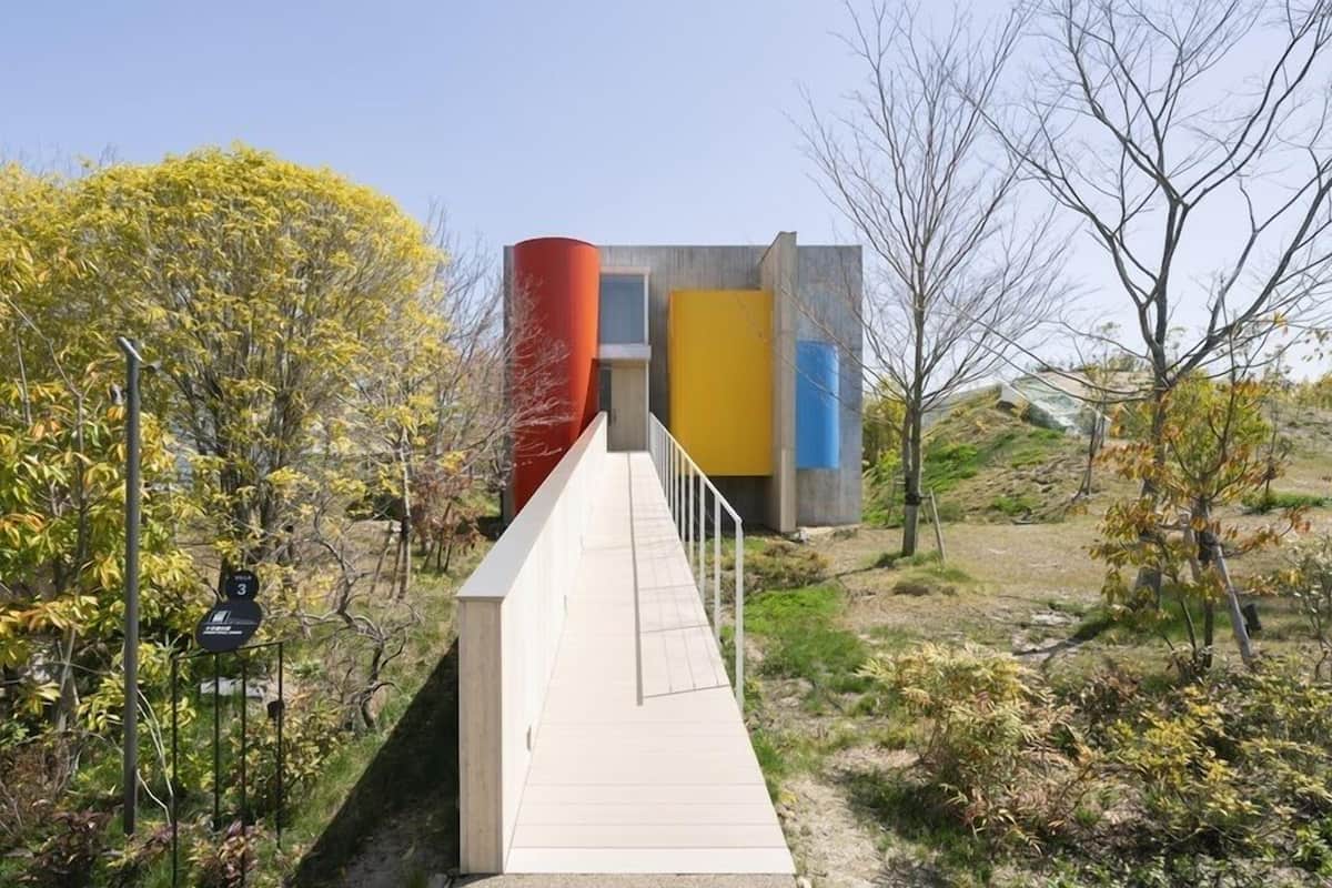 A pathway leading to a modern building with a unique facade.