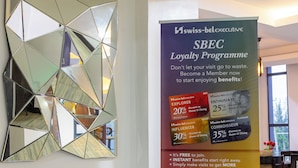 A hotel lobby with a geometric mirror art piece and a promotional stand for the Swiss-Belhotel SBECLoyalty Programme. - Swiss-Belinn Nairobi (Nairobi)