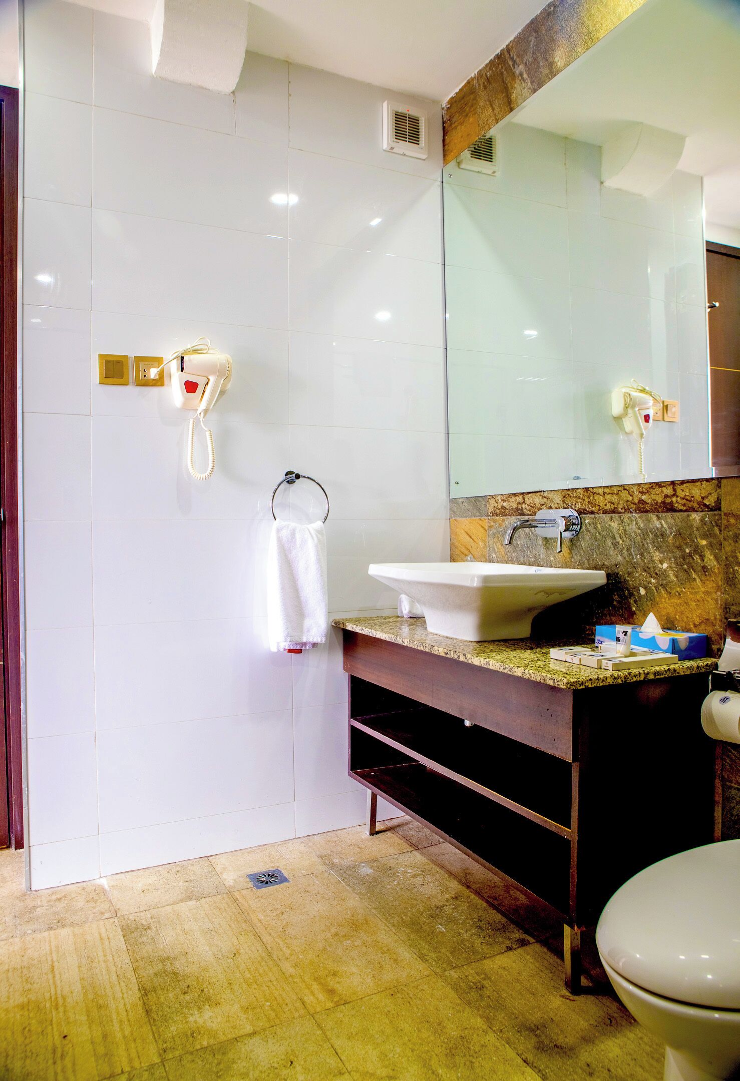 A bathroom with a white sink, a mirror, and a toilet.