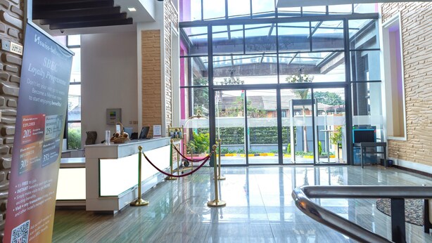 A modern hotel lobby with a reception desk, a glass partition, and a view of the outdoors. - Swiss-Belinn Nairobi (Nairobi)