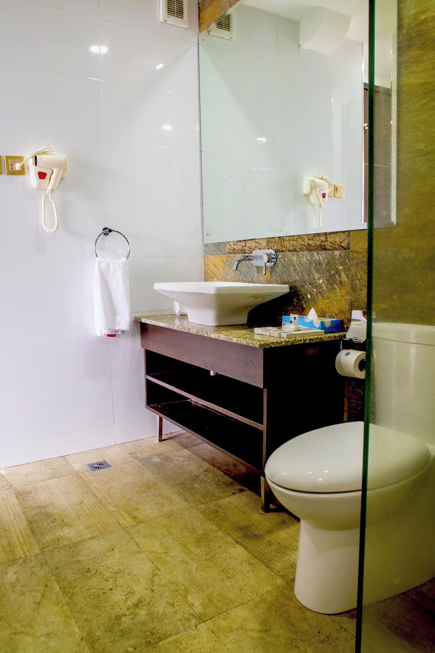 Een badkamer met een wit wastafelmeubel, een spiegel en een toilet.