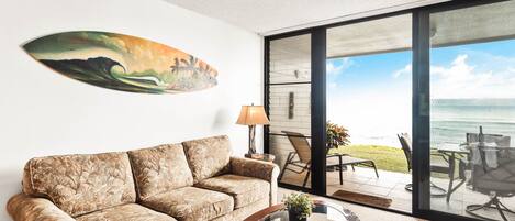 A living room with a sofa, a coffee table, and a painting on the wall.