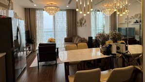 Una cocina moderna con comedor, que cuenta con una encimera de mármol, sillas de madera e iluminación colgante.