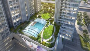 Un edificio residencial de gran altura con múltiples balcones, un patio central con piscina y abundante vegetación.
