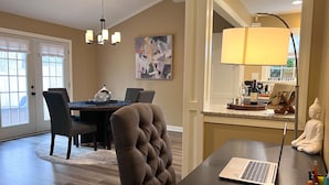 Un espace repas comprenant une table, des chaises et un ordinateur portable.