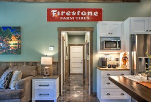 A kitchen with a microwave, coffee maker, and a water dispenser. There's a sign for 'Firestone Farm Tires' on the wall.