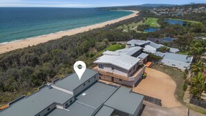 Una zona residencial moderna con vista al mar, con casas de techos grises y paneles solares.