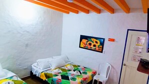 A small, simple room with a bed, a chair, and a door. - JUHALU (Jericó)