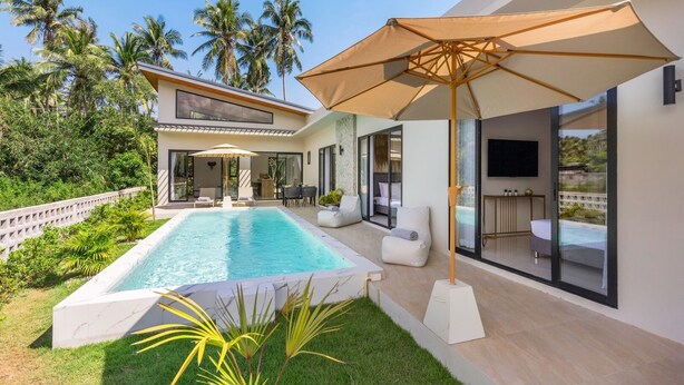 A modern house with a swimming pool, outdoor seating, and a large umbrella. - Sereniwood 2 - 3 Bedroom Pool Villa (Koh Samui)