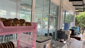 A kitchen area with a pink appliance, a large window, and various kitchen items on the counter. - Chatchawan Resort (Uttaradit)