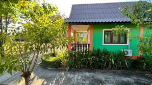 A small, colorful house with a green and orange exterior, a tiled roof, and a window. - Chatchawan Resort (Uttaradit)