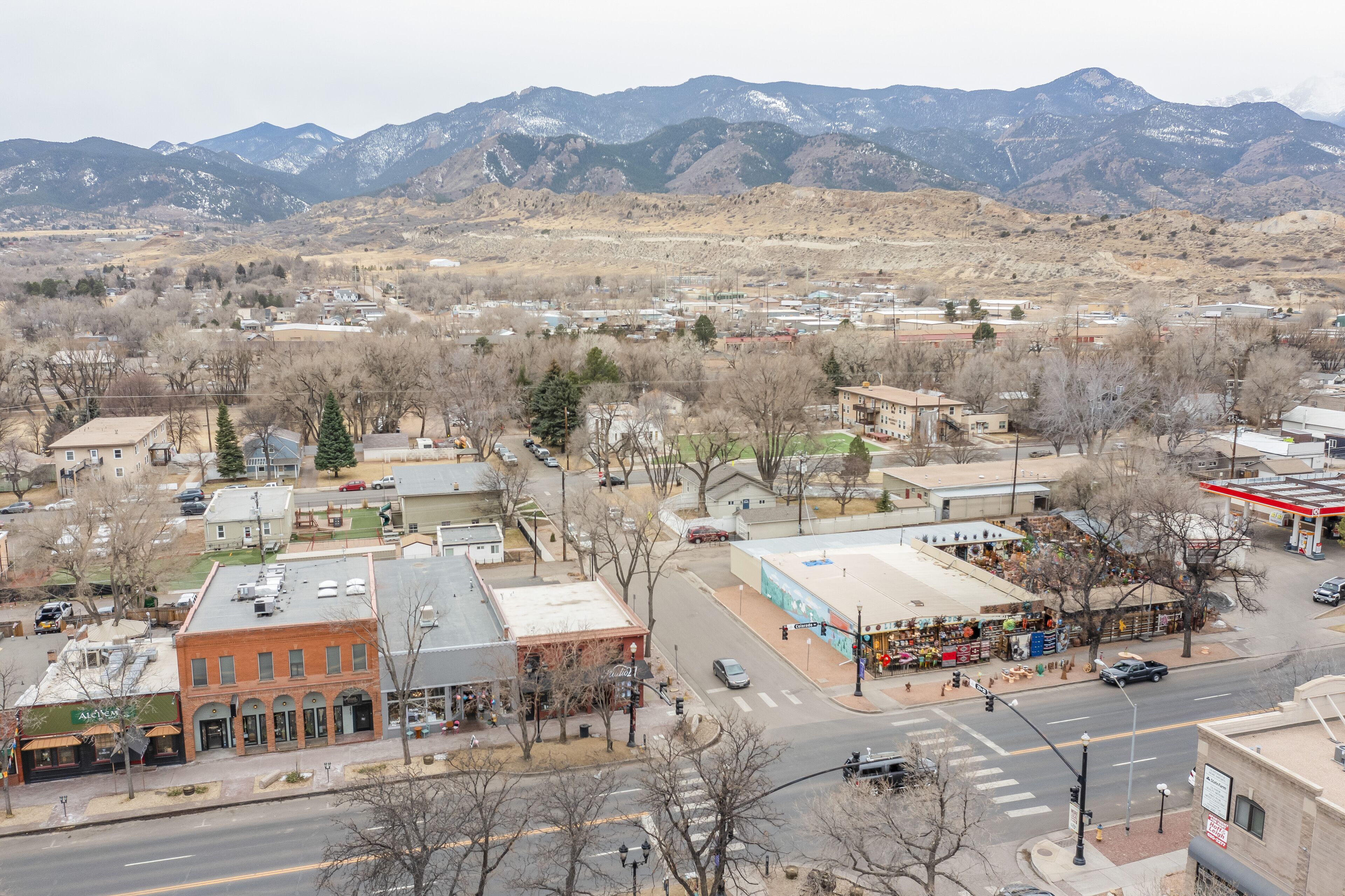 A town with a gas station, a small plaza, and buildings with a mountain backdrop.