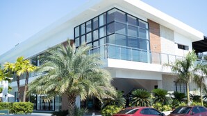 A modern building with large glass windows, a flat roof, and a white facade. - Asaricha Tropical Beach Resort (Pasuquin)
