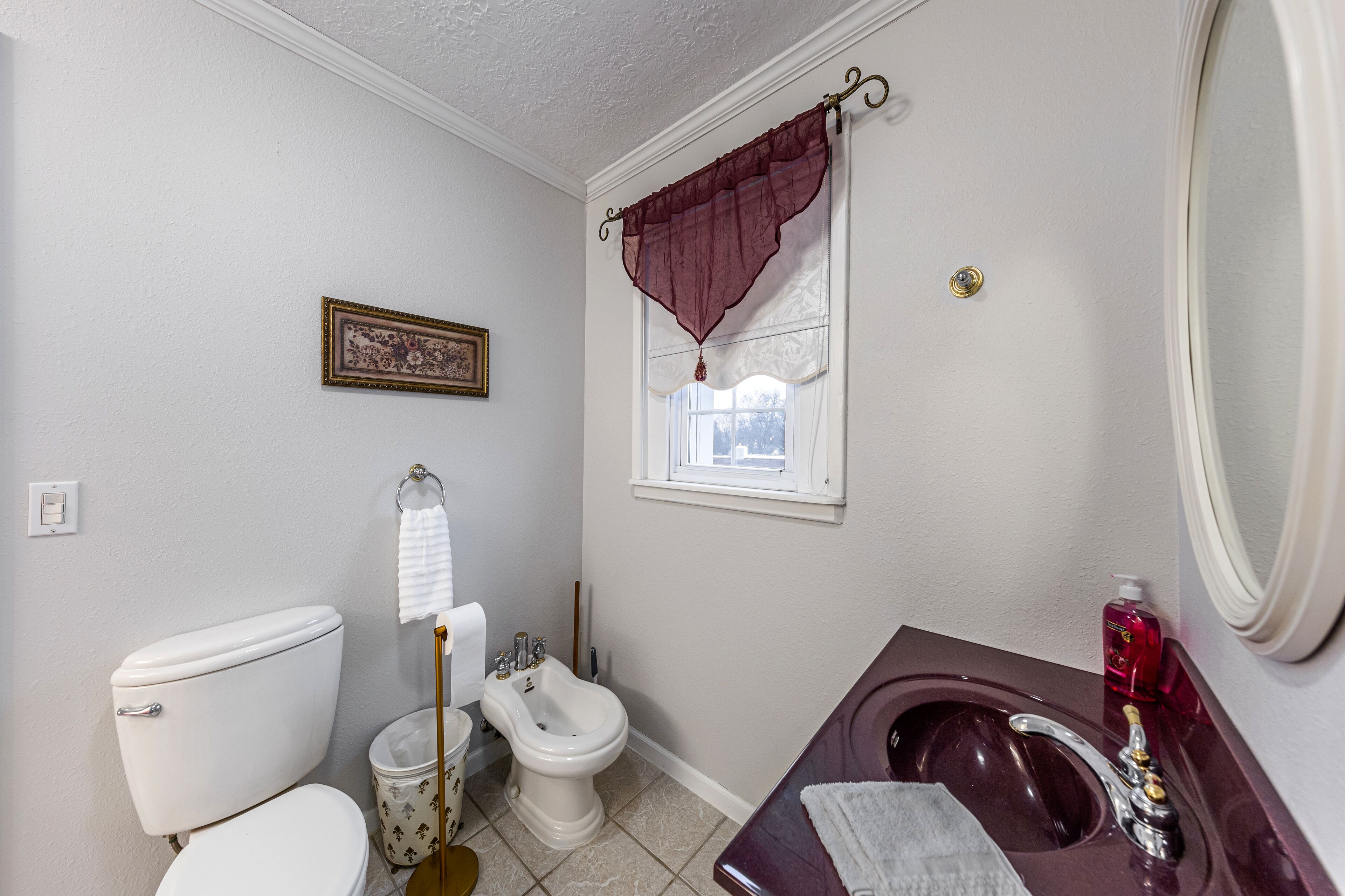 A bathroom with a toilet, bidet, and a sink with a mirror.